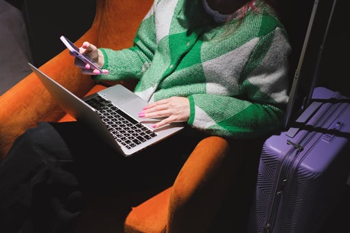 AIOps woman standing with laptop next to a suitcase