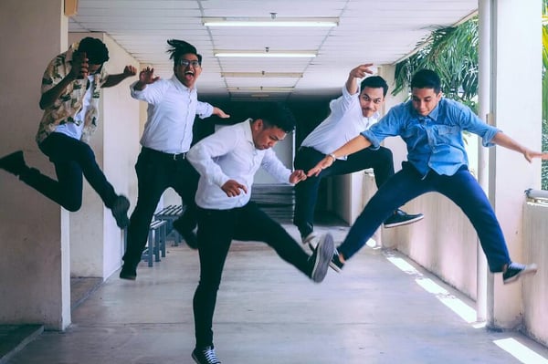 5 men who work within the SAP industry, jumping for joy in an outdoor corridor because their SAP Basis roles are understood.