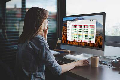 Eine junge Frau sitzt vor ihrem Desktop-Computer, die vor kurzem mit freundlicher Genehmigung von Avantra auf SAP HANA Monitoring migriert hat.